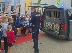 policjant przy samochodzie i grupa dzieci