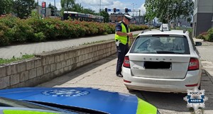 policjant przy aucie widac tez fragment radiowozu