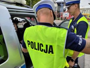 dwaj policjanci przy radiowozie