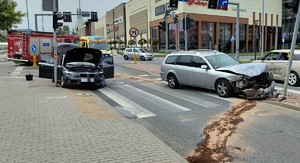 miejsce wypadku dwa rozbite auta i pojazdy słuzb