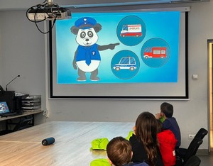 ekran  z prezentacją dzieci przy stole
