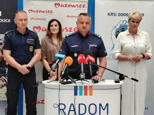 zastępca komendanta a za nim 3 osoby podczas konderencji