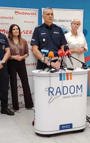 naczelnik ruchu drogowego a za nim uczestnicy konferencji prasowej