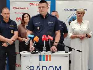 zastępca naczelnika wydziału prewencji a za nim uczestnicy konferencji prasowej