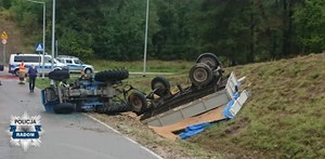 miejsce wypadku w Iłży, ciągnik rolniczy z przyczepa przewrócony w tle radiowozy