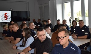 grupa policjantów siedząca przy stole podczas szkolenia