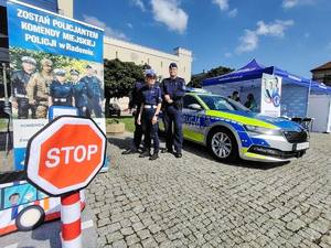 policjanci przy radiowozie na pikniku o bezpieczeństwie