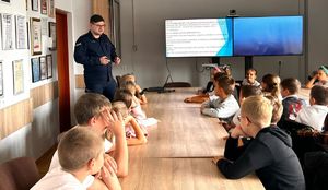 policjant i grupa dzieci na świetlicy w tle ekran