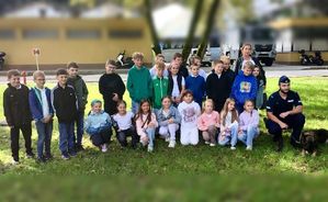 zdjęcie grupowe dzieci i policjant z czworonogiem