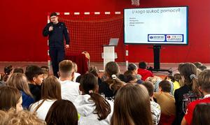 policjant w tle ekran na spotkaniu  z grupą z uczniów