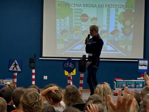 policjantka i dzieci podczas spotkania w tle ekran z prezentacją