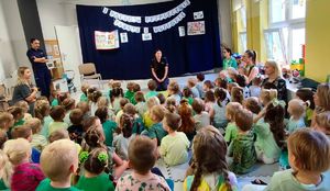 grupa przedszkolaków w sali  w tle dwie policjantki