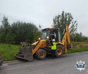 policjant kontroluje trzeźwość kierowcy koparki
