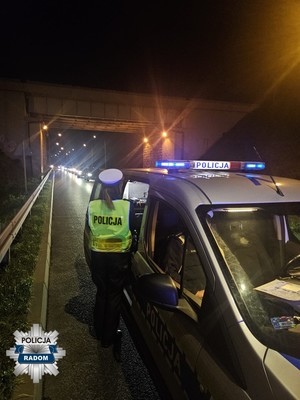 policjantka przy radiowozie na ulicy wieczorem