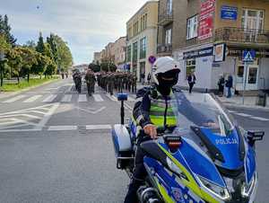 policjant na motocyklu w tle uczestnicy przemarszu