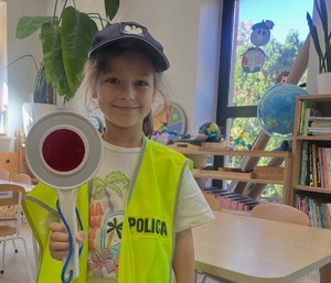 dziewczynka  w policyjnej czapce i kamizelce