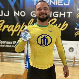 policjant w sportowym stroju trzyma medal