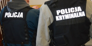 dwaj policjanci  w kamizelkach czarnych z napisem policja