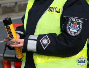 zdjęcie fragmentu umundurowania dłoń policjantki i urzadzenie do badania tzreźwości