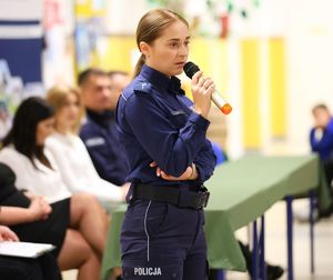 policjantka mówi do mikrofonu podczas prelekcji