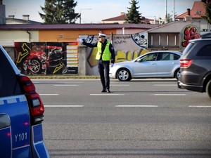 policjant na ulicy między pojazdami kieruje ruchem