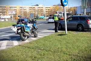 policjant i słuzbowy motocykl na ulicy podczas zabezpieczenia