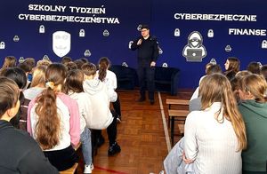 policjant i grupa uczniów na sali