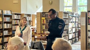 policjant i pracownica zakładu ubezpieczeń społecznych w bibliotece podczas spotkania