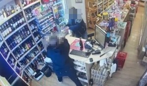 ujęcie sklepu z kamery, widac produkty, kase i dwie postacie