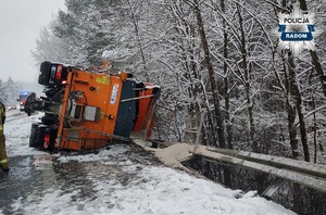 pługopiaskarka leżaca na boku po wypadku na ulicy