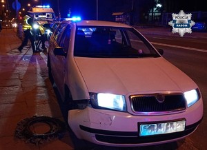 pojazd a w tle policjanci