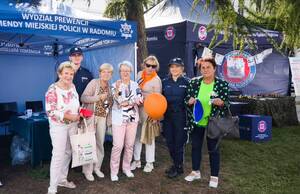 dwoje policjantów i 5 seniorek pozuje do wspólnego zdjęcia w tle namiot profilaktyczny policji