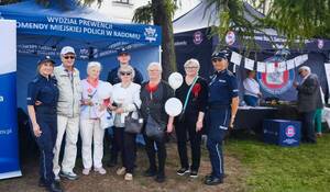 troje policjantów i 5 seniorów pozuje do wspólnego zdjęcia w tle namiot profilaktyczny policji