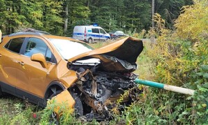 uszkodzony pojazd na miejscu zdarzenia w tle radiowóz