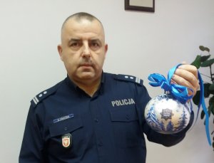 Umundurowany policjant trzymający bombkę choinkową
