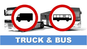 zdjęcie przedstawia autokar oraz samochód ciężarowy w kolorze czarno - białym. Na pierwszym planie usytuowane są dwa koła z czerwonym otokiem. Wewnątrz kół narysowane są zarys samochodu ciężarowego oraz autobusu. Pod spodem umieszczony jest biały napis &quot;truck&amp;bus
 na niebieskim tle