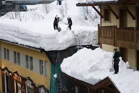 grafika przedstawia dwie osoby zsuwające z dachu śnieg