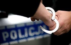 Napis POLICJA kajdanki zakładane na ręce