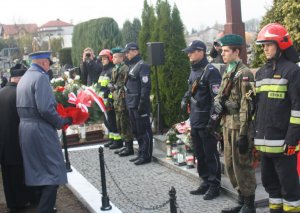 Komendant Powiatowy Policji w Lipsku mł. insp. Wojciech Brandt i ks. kan. Henryk Jagieło składają kwiaty przy płycie.