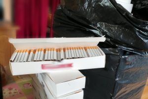 papierosy w kartonie i tytoń w czarnym worku