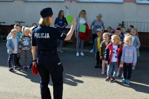 policjantka tłumaczy grupie dzieci zasady ruchu pieszych
