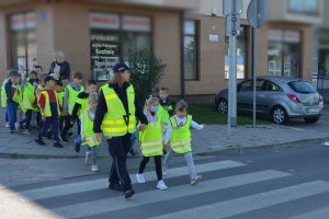 policjantka przeprowadza grupę dzieci przez przejście dla pieszych