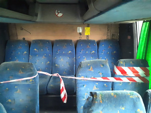 wnętrze autobusu, zamiast tylnej szyby karton i taśma, którą przewiązane są fotele