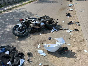 rozbity motocykl, leżący na drodze