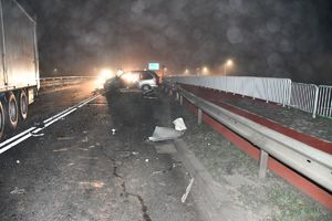 Fotografia kolorowa: wypadek drogowy droga relacji Mława - Szydłowo, widzimy na drodze zniszczony pojazd marki Dodge.