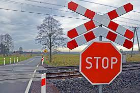 Fotografia kolorowa: przejazd kolejowy ze znakiem STOP.