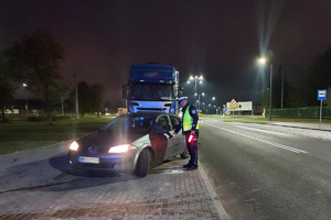 Fotografia kolorowa:  patrol policji kontrolujący pojazd osobowy