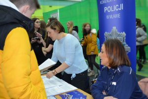 policjantka udziela informacji uczniom na stoisku KPP w Mławie