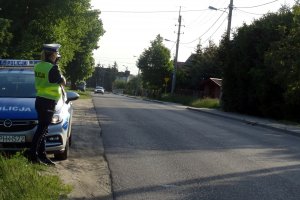 droga, na poboczu radiowóz, policjantka prowadzi pomiar prędkości