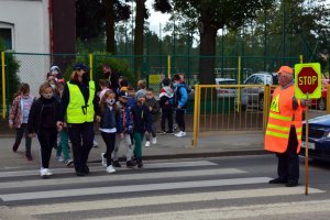 policjantki prowadzą spotkane z dziećmi w pobliżu przejście dla pieszych